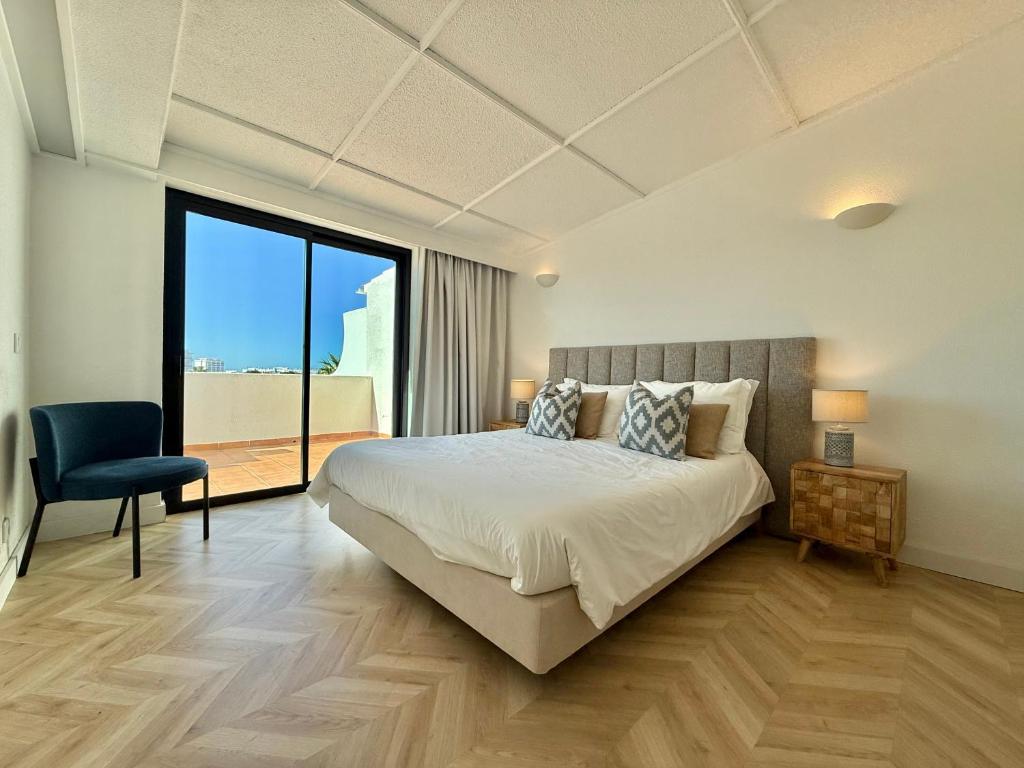 a bedroom with a large bed and a large window at Penthouse S.Jorge Seaview T4 in Quarteira