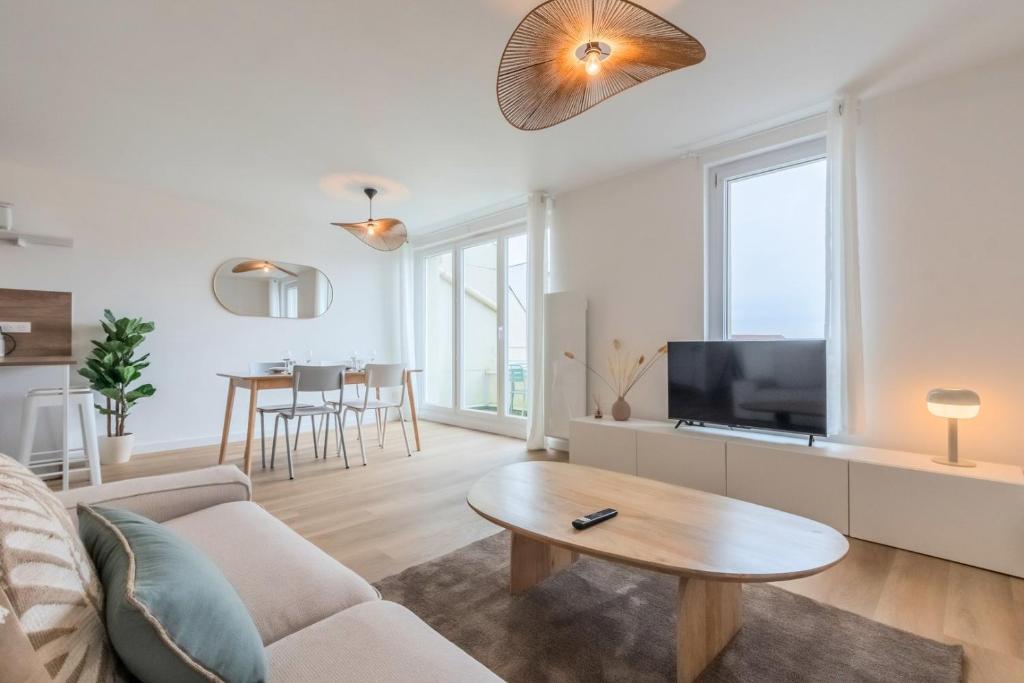 un salon avec un canapé et une table dans l'établissement Appartement 2 chambres avec parking et balcon, à Marcq-en-Barœul