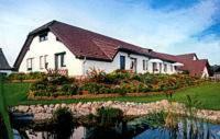 ein Haus mit einer Reflexion in einem Wasserkörper in der Unterkunft Hotel-Pension Märkischheide in Vetschau