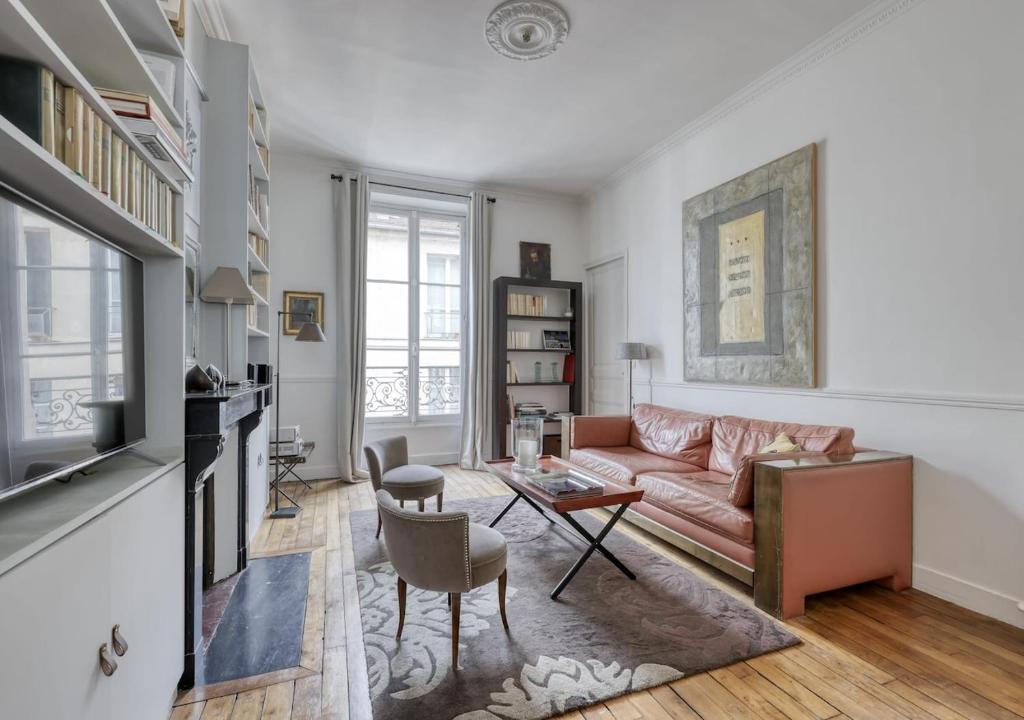 un salon avec un canapé et une table dans l'établissement Spacious Typical Parisian Flat - Paris Le Marais, à Paris