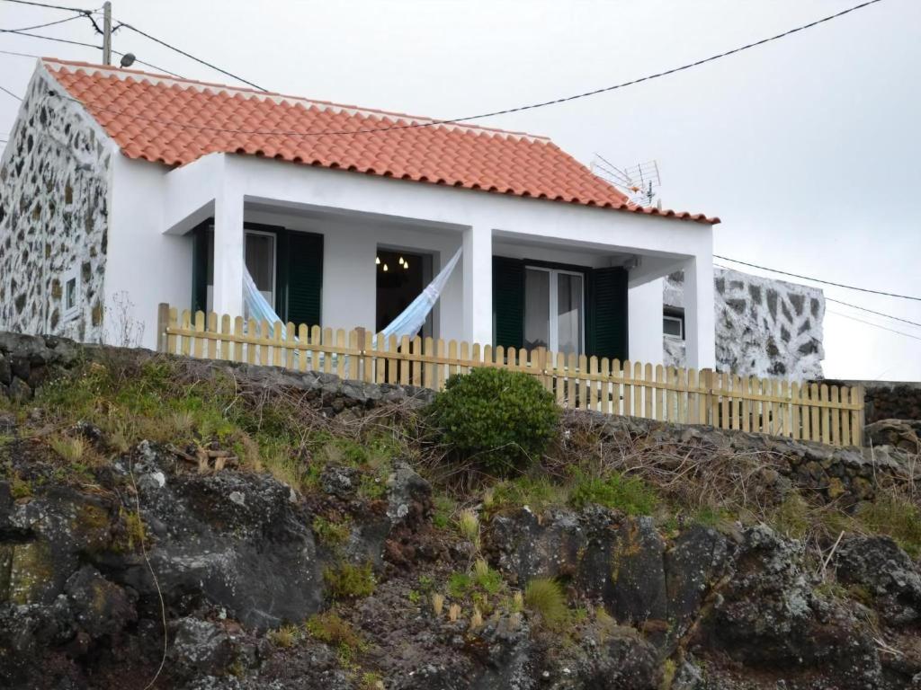 ein Haus auf einem Hügel mit einem Zaun in der Unterkunft Ferienhaus für 2 Personen ca 60 m in Feteira, Azoren Terceira in Angra do Heroísmo