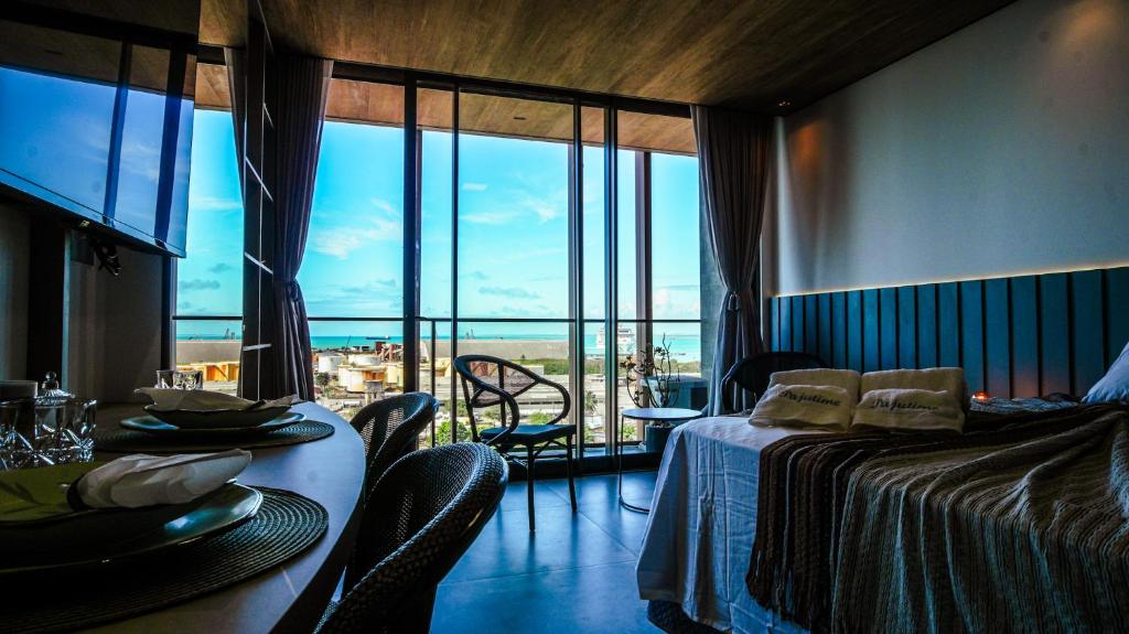 Habitación con cama y mesa con vistas. en New Time Paju 1110, en Maceió