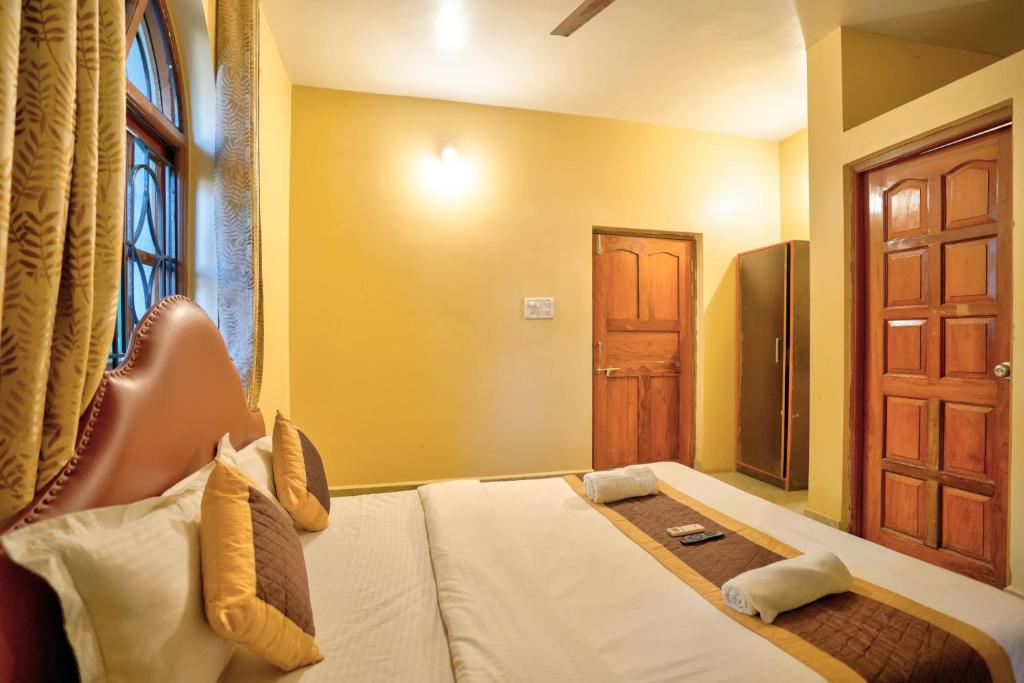 a hotel room with a bed and a door at Roseal Beach Front in Baga
