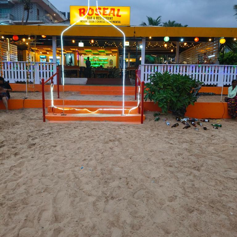 a restaurant with an orange gate in the sand at Roseal Beach Front in Baga