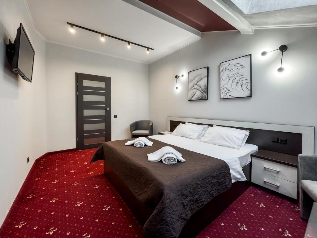 a bedroom with a bed with two towels on it at Apartments On Zaliznychna 49 in Ivano-Frankivsʼk