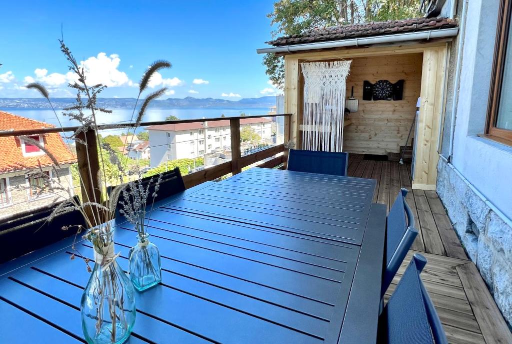 - une table sur un balcon avec vue sur l'océan dans l'établissement Maison du garde barrière - Atypique et chaleureuse, à Évian-les-Bains