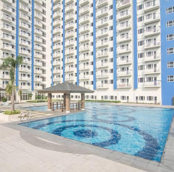 a large swimming pool in front of a large building at Quezon City Luxury Condo Unit Sun Residences Welcome Rotonda España in Manila