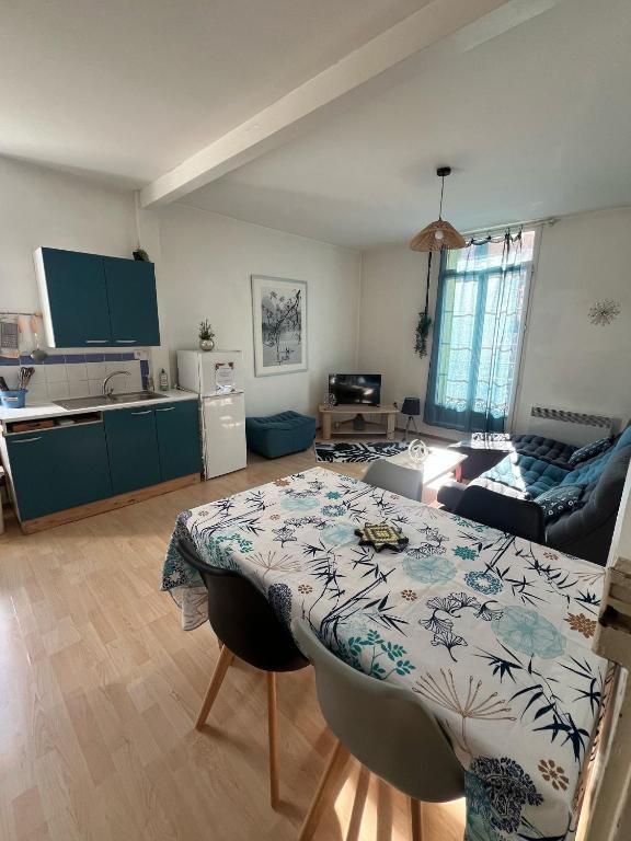 une cuisine et un salon avec une table dans une pièce dans l'établissement Les Platanes - Gaugain, à Lamalou-les-Bains