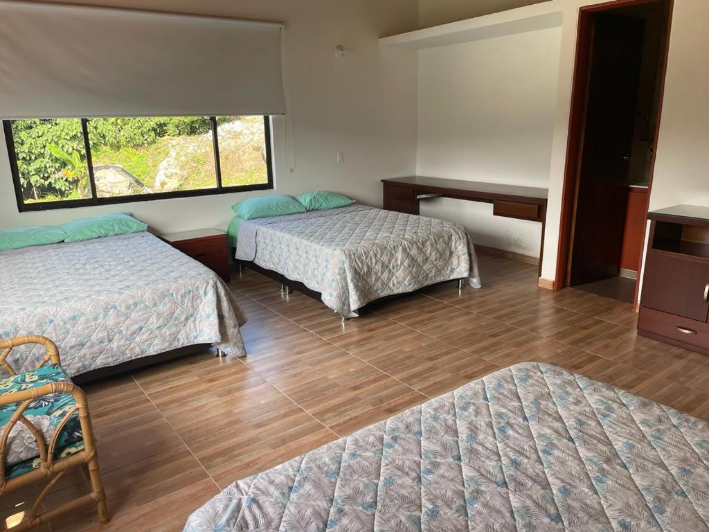 a hotel room with two beds and a window at Hotel y Restaurante la Florida in Páramo