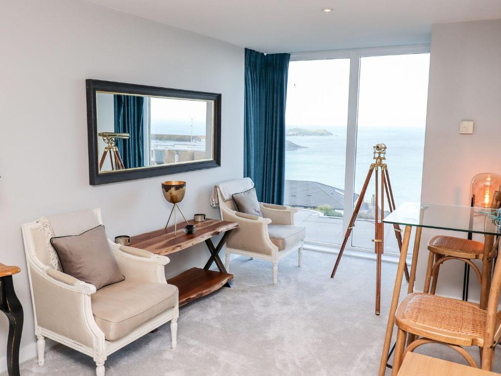 een woonkamer met stoelen en een tafel en een raam bij Wingspan in St Ives
