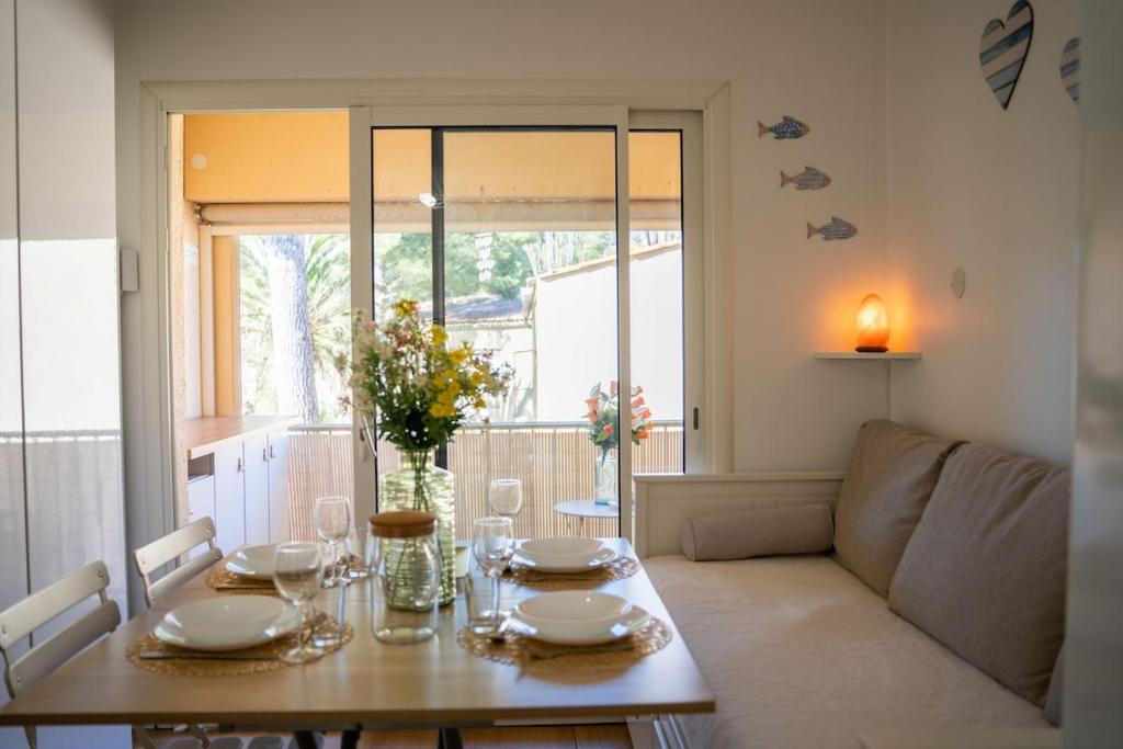 d'une table à manger et d'un canapé dans le salon. dans l'établissement Charmant studio à sanary - résidence avec piscine, à Sanary-sur-Mer