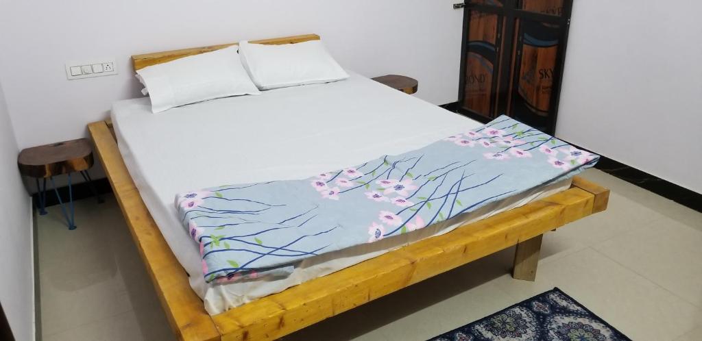 a bed in a room with a white bedspread with flowers on it at Sukoon - The Bliss in Udaipur