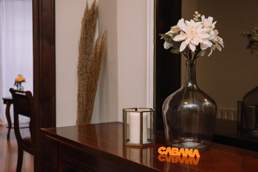 un vase de fleurs sur une table avec une bougie dans l'établissement Clásico en el centro de Vigo by CABANA Rentals, à Vigo