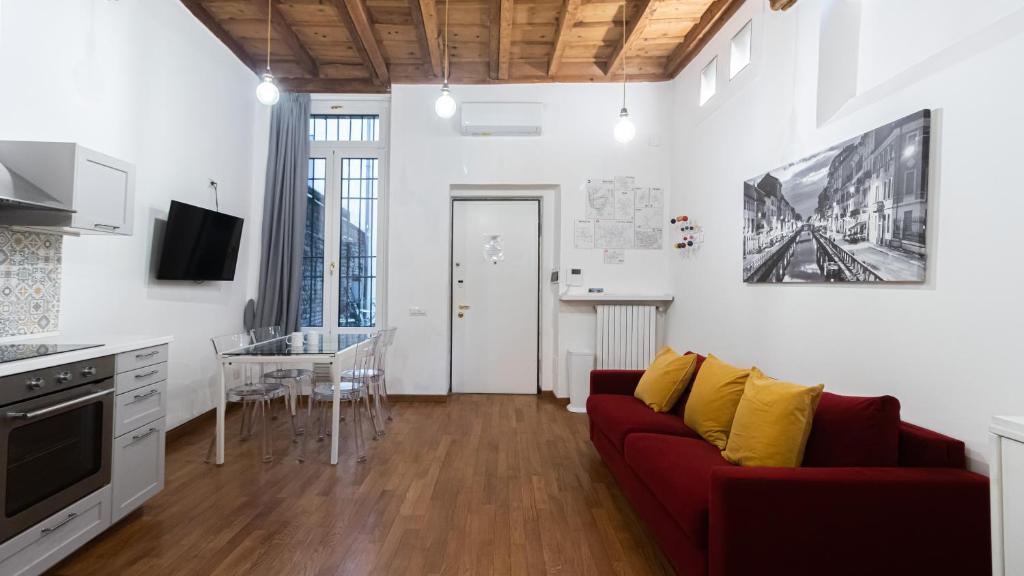 salon z czerwoną kanapą i stołem w obiekcie Italianway - Porta Ticinese 67 w Mediolanie