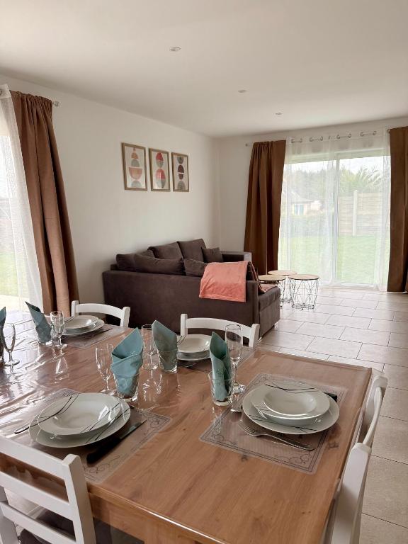 une salle à manger avec une table et des chaises en bois dans l'établissement Les gîtes Pléhédelais TER, à Pléhédel