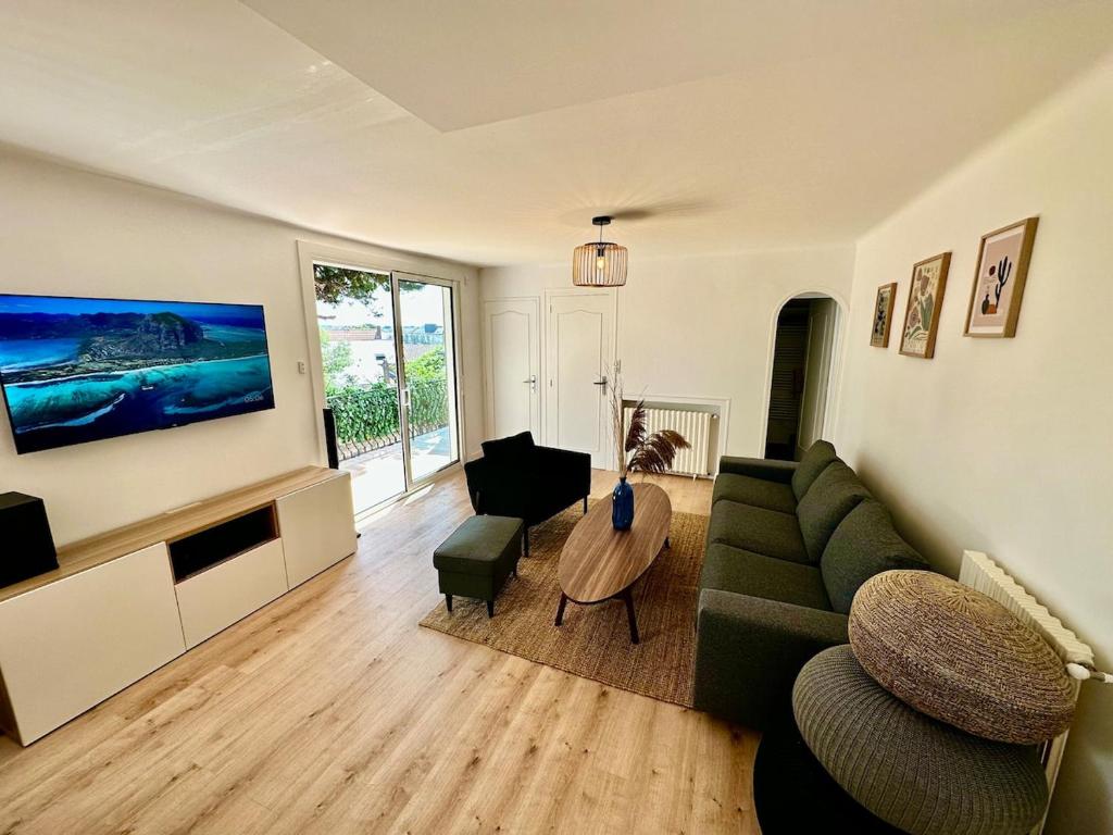 un salon avec un canapé vert et une table dans l'établissement Maison Spacieuse idéalement placée bord de mer, à Pornic