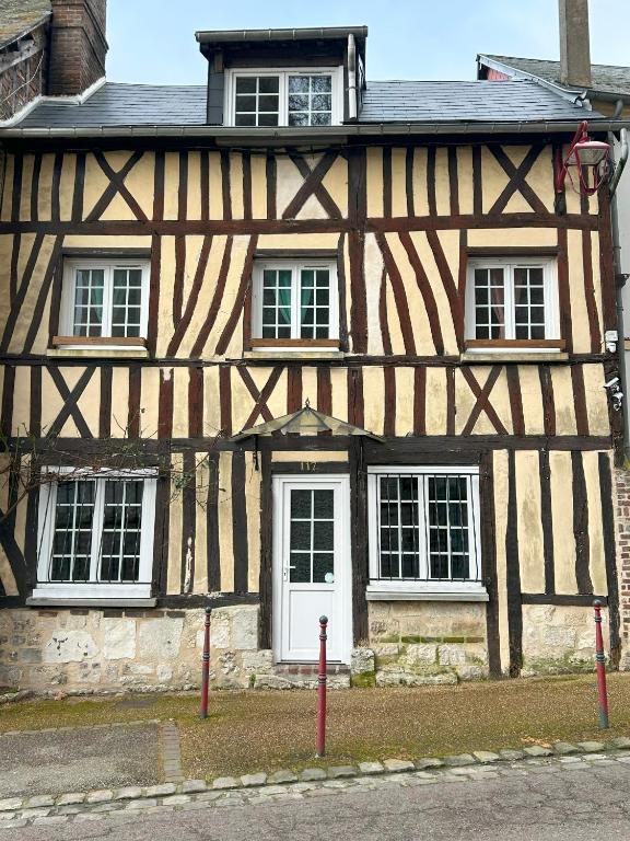 - un bâtiment ancien avec une porte et des fenêtres blanches dans l'établissement le relais de l'abbaye, à Jumièges
