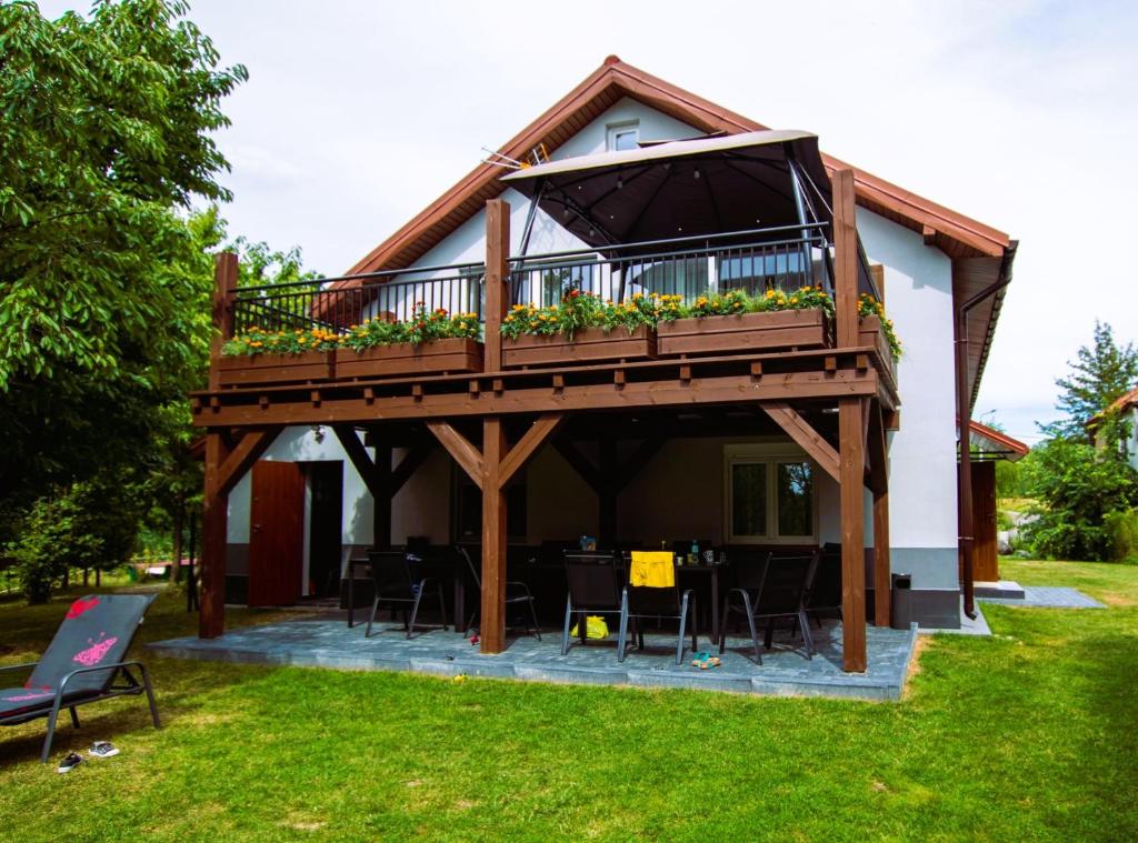 una casa con terraza con mesa y sillas en Dom nad Jeziorem Łaśmiady, en Sajzy