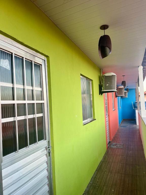 a room with a green wall and a door at Vivendas Raízes do forte in Praia do Forte
