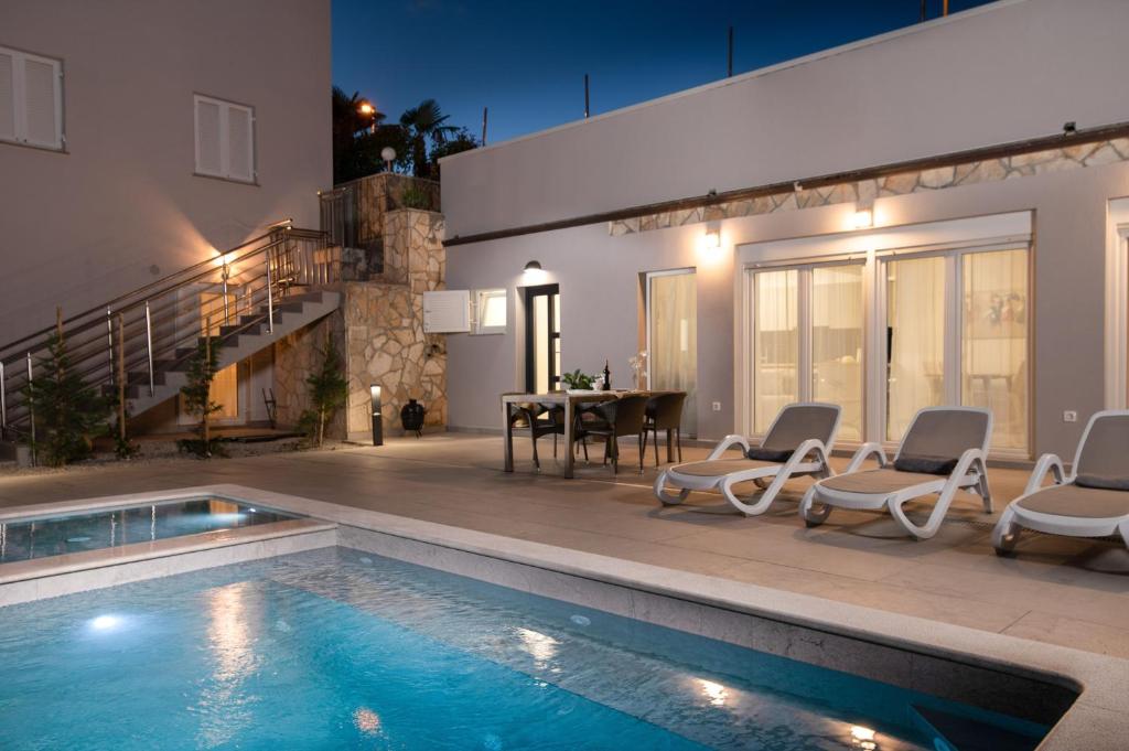 a house with a swimming pool and a dining room at Haus Quadro in Rabac