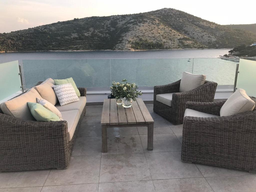 a patio with two chairs and a couch and a table at Apartment White House in Vinišće