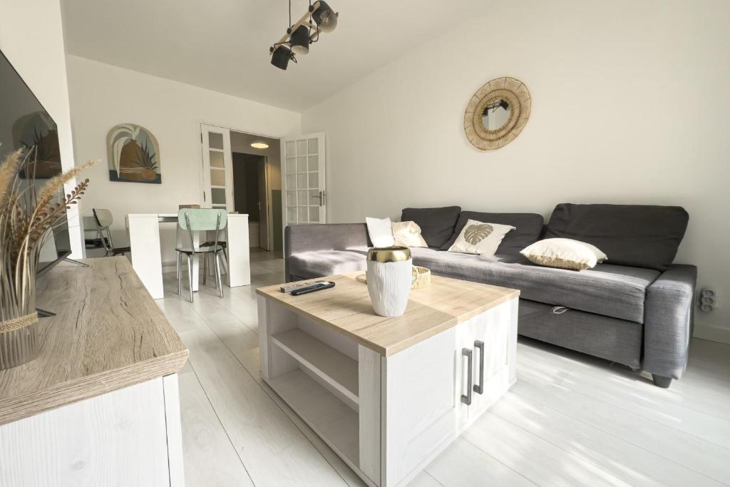 un salon avec un canapé et une table dans l'établissement #HR Les Charmilles T4, à Grenoble