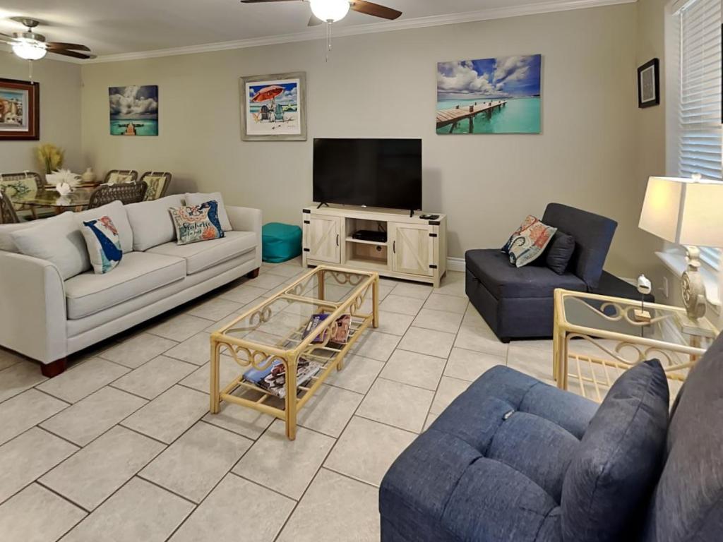 a living room with couches and a flat screen tv at 3 Sheets To the Zin in Port Aransas