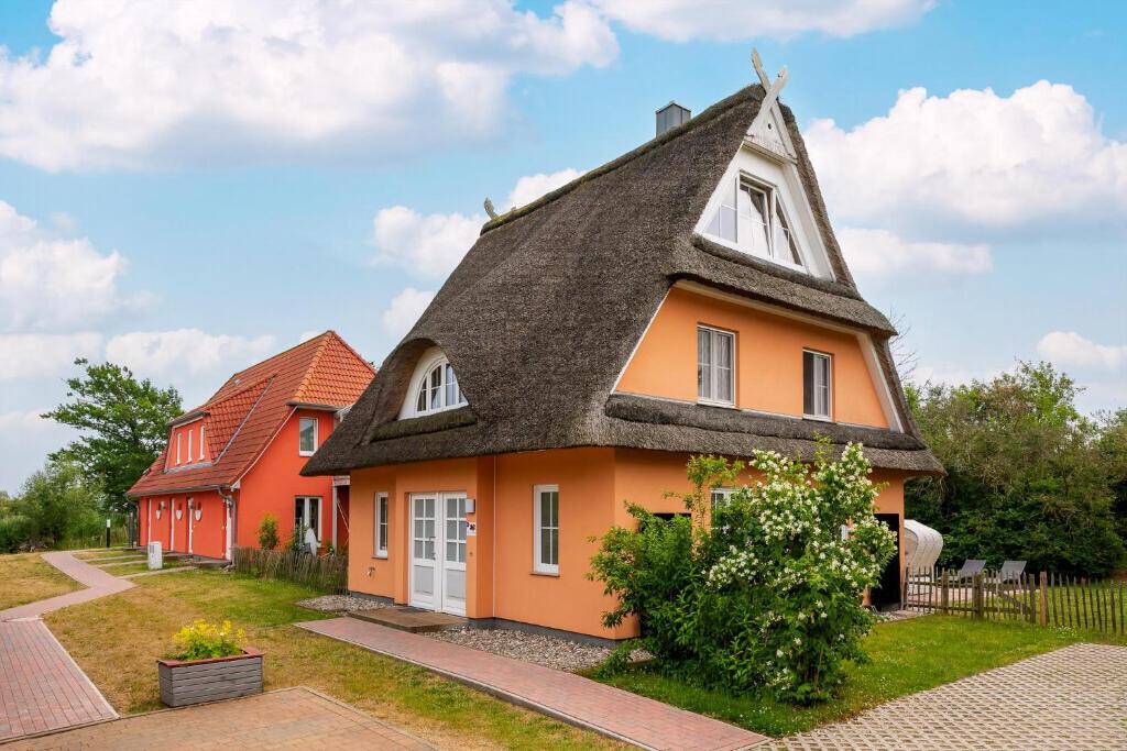 a small house with a thatched roof at Reethaus Remy Luxus In Beckerwitz in Gramkow