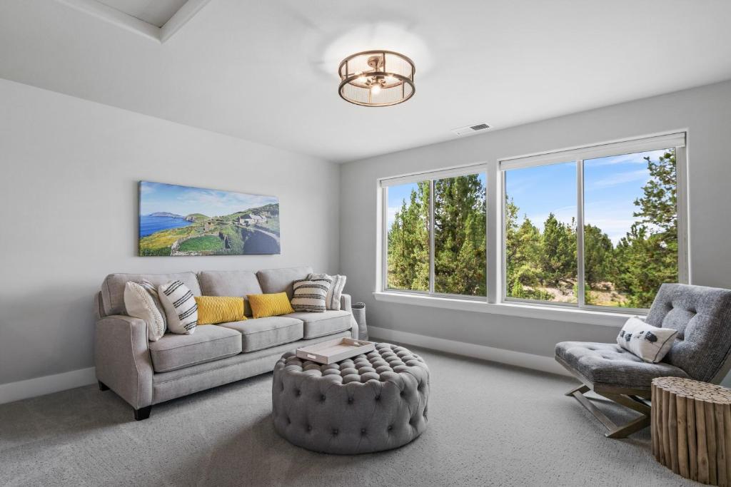 Una sala de estar con un sofá y una silla y ventanas. en Dara, en Bend