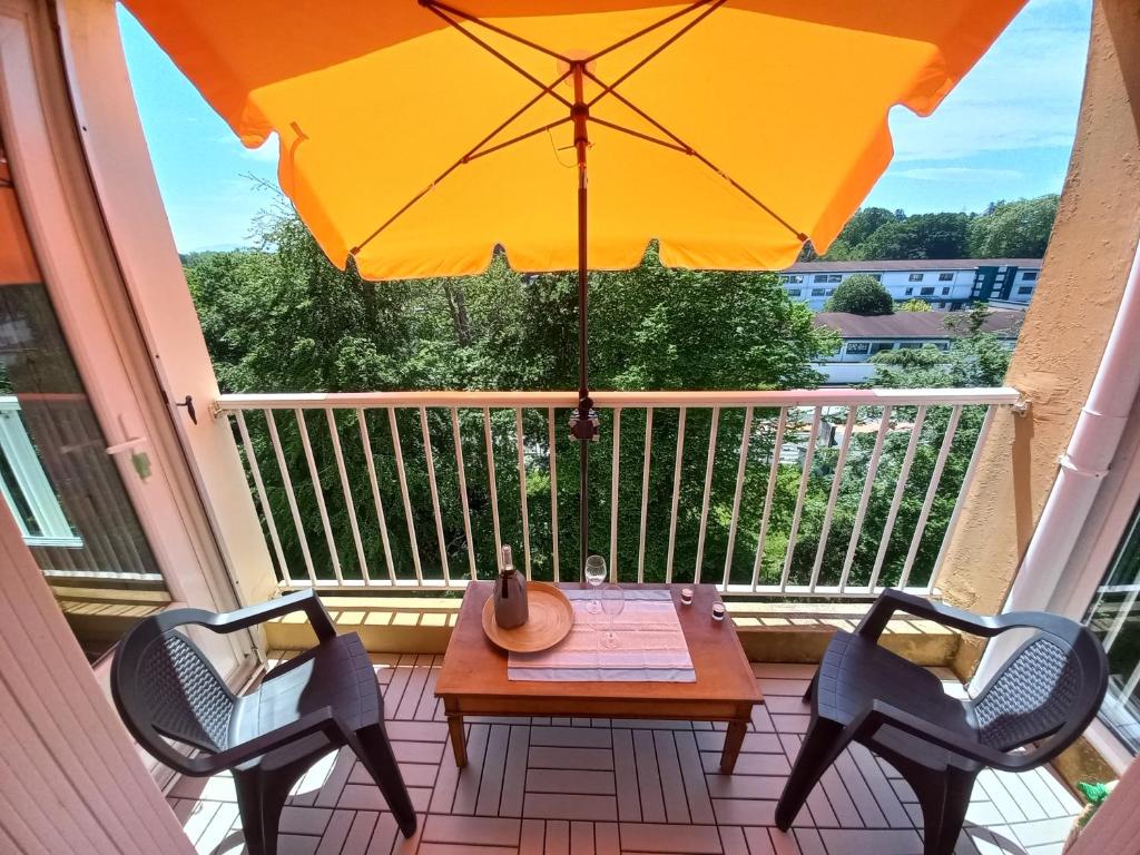 d'une table, de deux chaises et d'un parasol sur le balcon. dans l'établissement Appartement central et chaleureux sur côte pays basque pour 6 personnes, à Anglet
