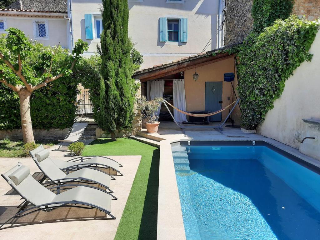 une piscine avec des chaises longues à côté d'une maison dans l'établissement Family Home Ventoux, à Mormoiron
