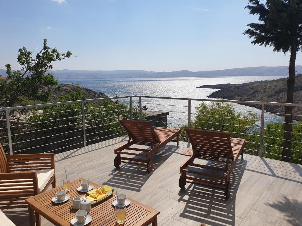 un ponte con sedie e tavoli e vista sull'acqua di Wohnung In Cesarica Mit Privater Terrasse a Cesarica