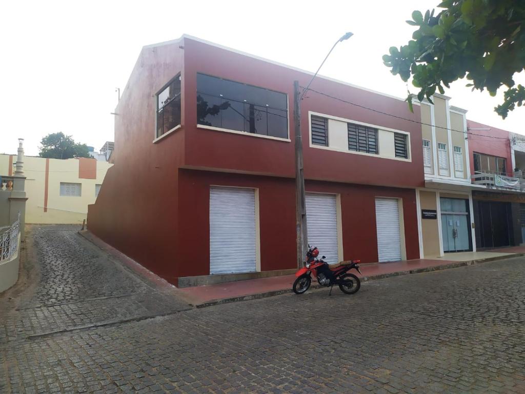 a motorcycle parked in front of a red building at Apartamento Central in Triunfo