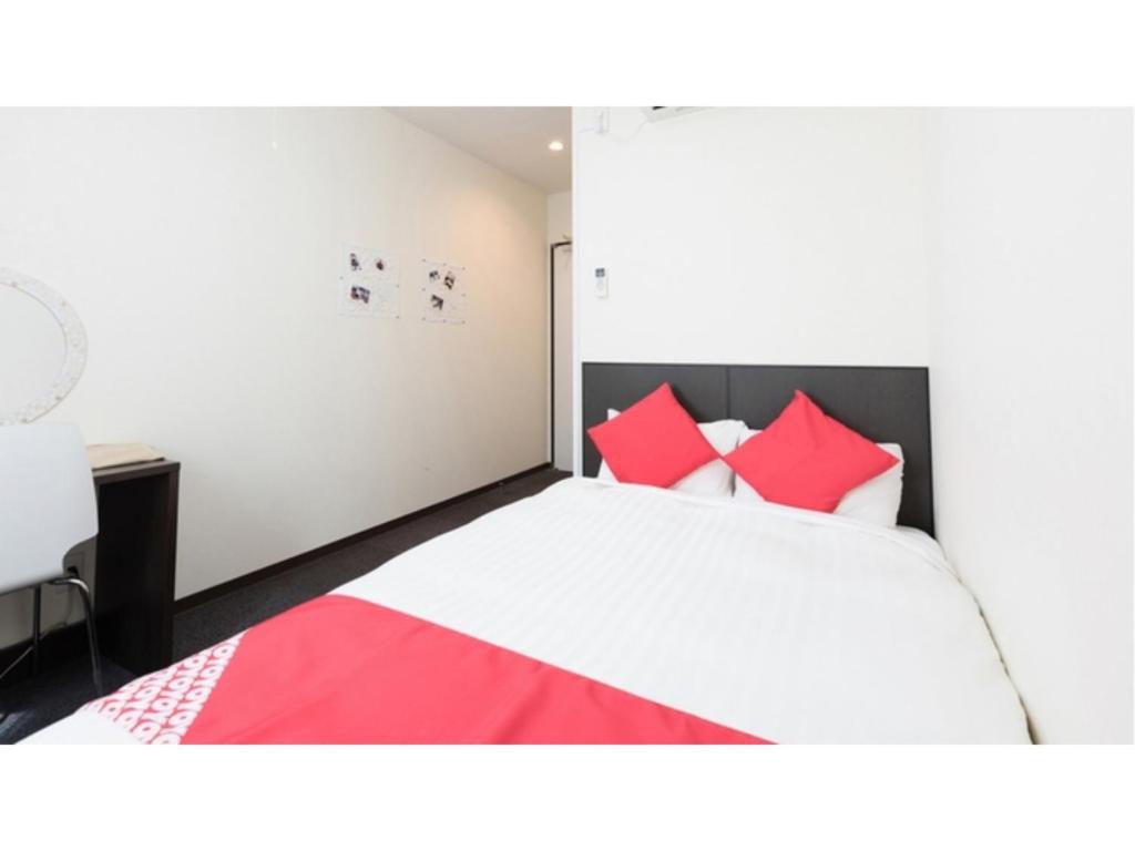 a bedroom with a large bed with red pillows at TAMA HOTEL - Vacation STAY 41312v in Ishinomaki