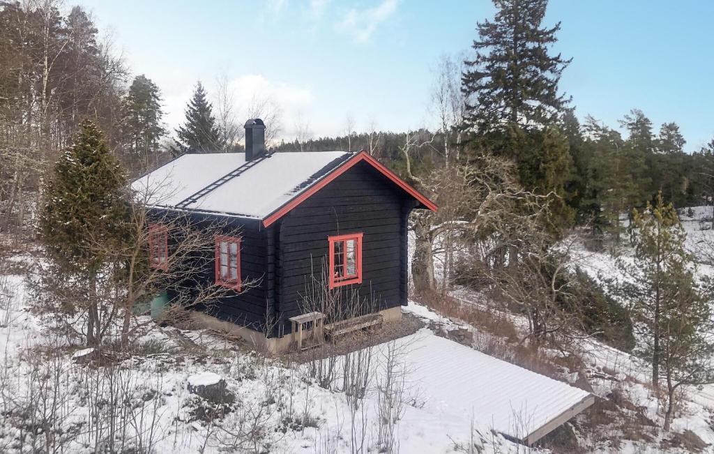 オーケシュバーリアにある1 Bedroom Cozy Home In Åkersbergaの雪面赤い窓のある小さなキャビン