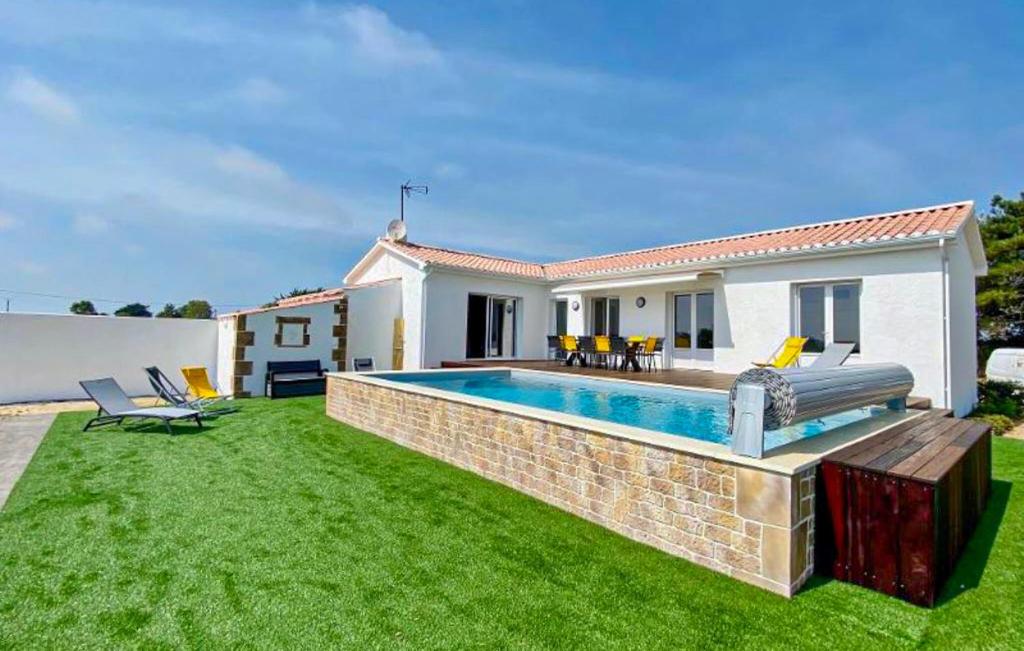 a backyard with a swimming pool and a house at Villa Avec Piscine Privée in Saint-Jean-de-Monts