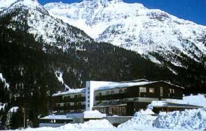 a building in front of a snow covered mountain at Hotel Canin in Sella Nevea