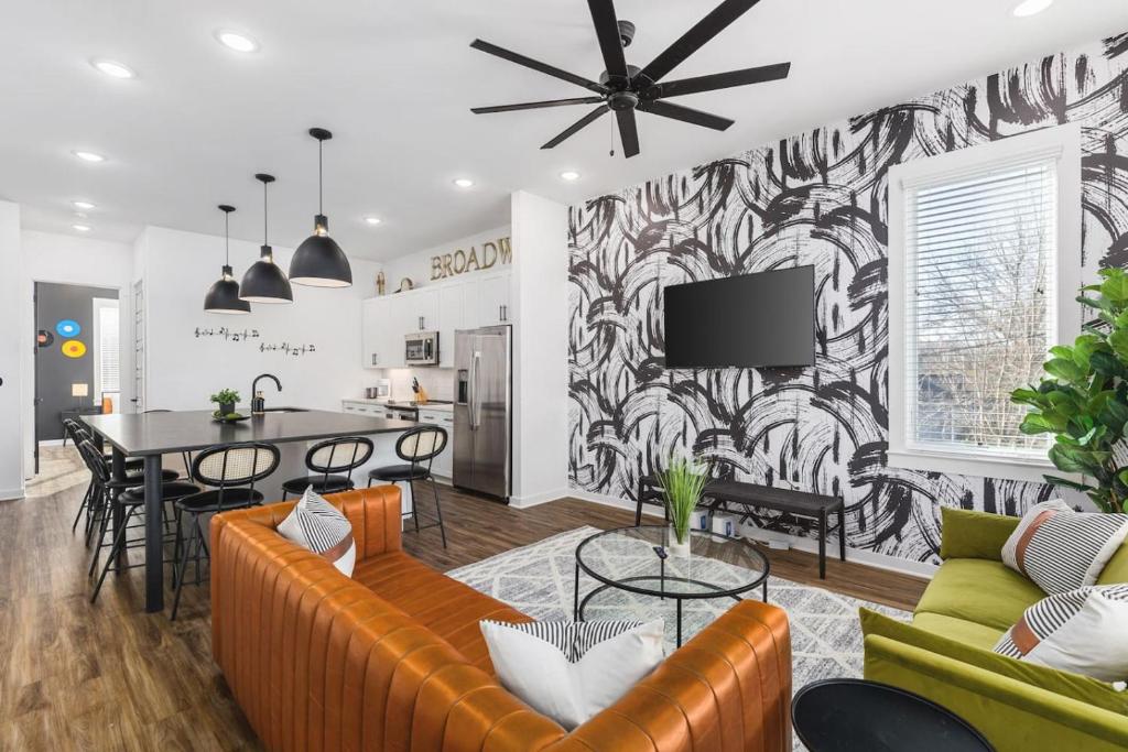 una sala de estar con un sofá y una mesa en TWO Adjacent Homes Sleeps 24 Only 3 miles to Broadway, en Nashville