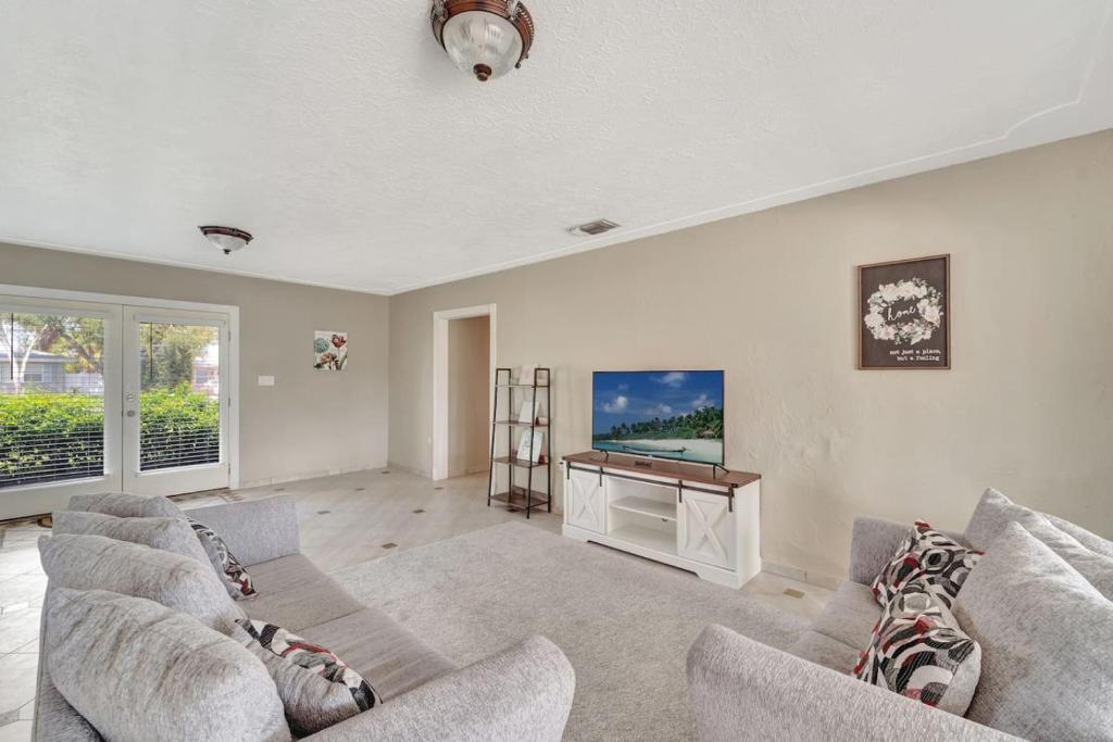 a living room with two couches and a television at Cozy Private Rm Near Beach Travelers Welcome J1A shared home in Sarasota