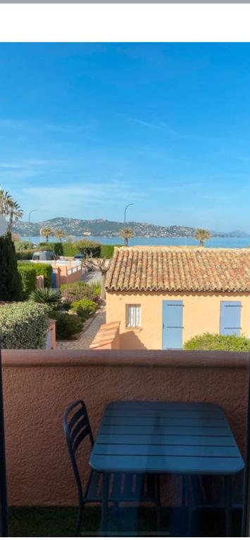 un banc bleu assis sur un balcon avec vue sur une maison dans l'établissement Appartement classé 3 étoiles face à la plage de la Nartelle, à Sainte-Maxime