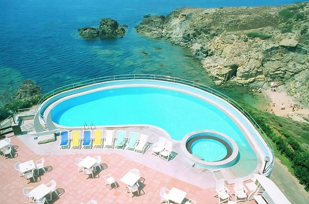 een uitzicht over een zwembad naast de oceaan bij Zeeva Hotel and Resort in Torre Dei Corsari