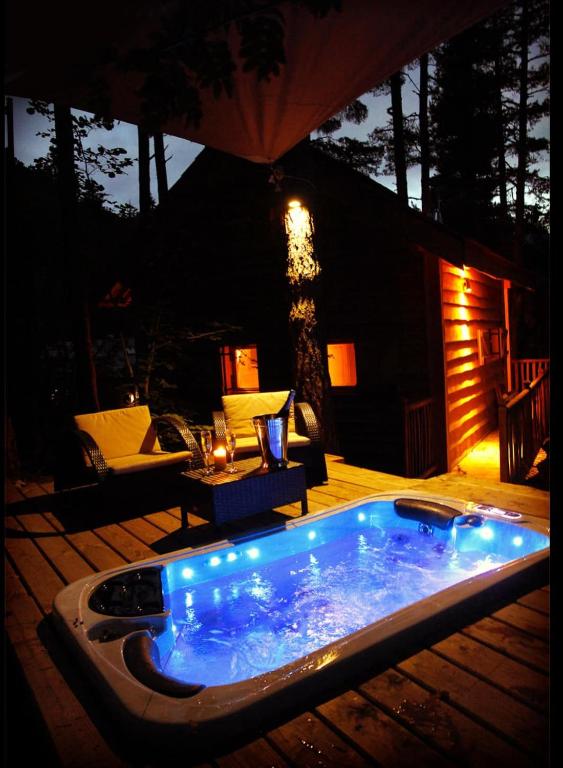 une baignoire jacuzzi assise sur une terrasse la nuit dans l'établissement Cabanes des Pins Sylvestres Boréon, à Saint-Martin-Vésubie