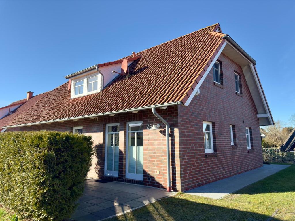 a red brick house with a brown roof at gemütliche Doppelhaushälfte in Burhave in Burhave