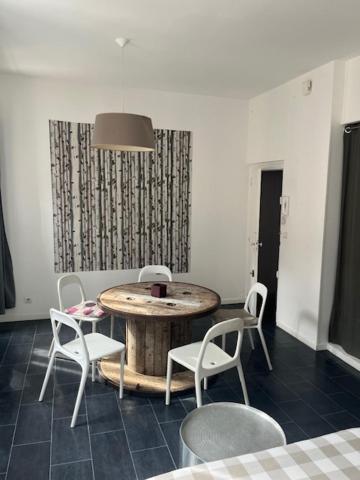 Cette chambre comprend une table et des chaises en bois. dans l'établissement studio balcon toulouse gare, à Toulouse