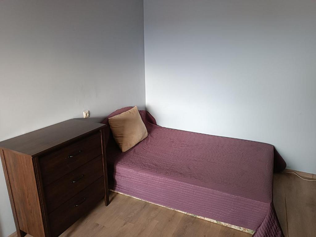 a small bedroom with a bed and a dresser at Piekrastes casa in Jūrmala