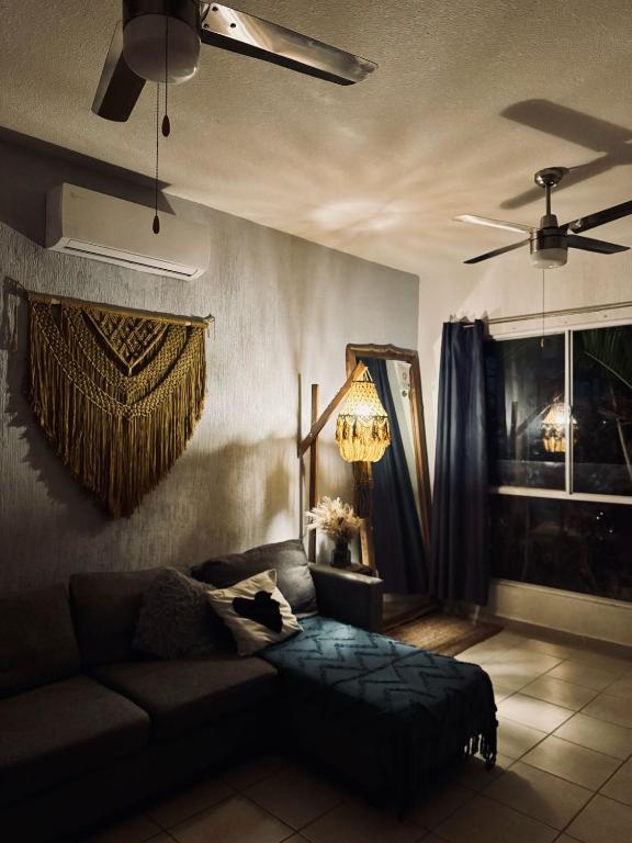 a living room with a couch and a ceiling fan at casa coyuca 4 in Cancún