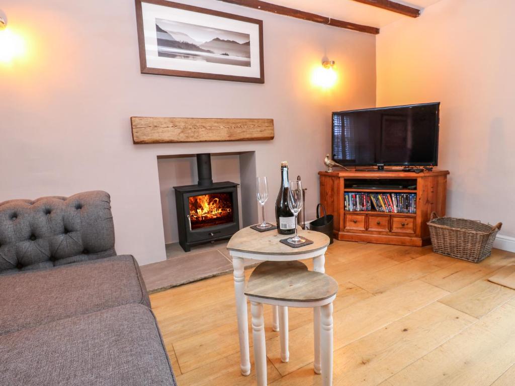 a living room with a table and a fireplace at Pheasant Cottage in Richmond