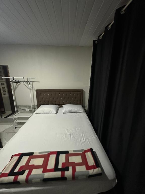 a bedroom with a bed with a black and red comforter at Suite para até 4 pessoas cataratas in Foz do Iguaçu