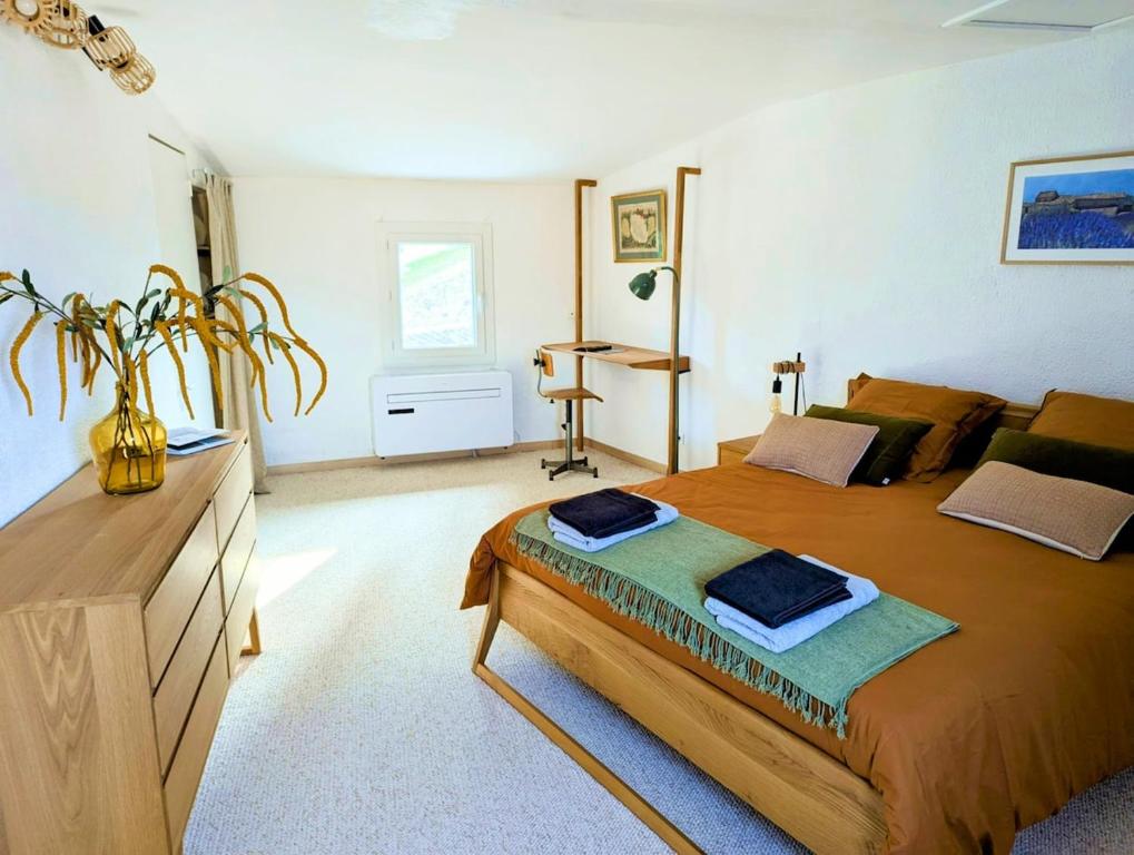 une chambre avec un grand lit et une commode dans l'établissement Le Joannis - Tranquillité en centre historique, à Malaucène