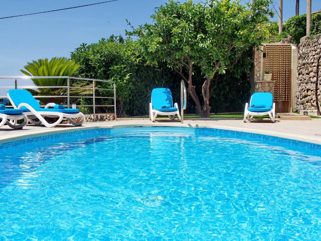 una piscina con due sedie blu e una piscina di House Sunce a Orasac (Valdinoce)